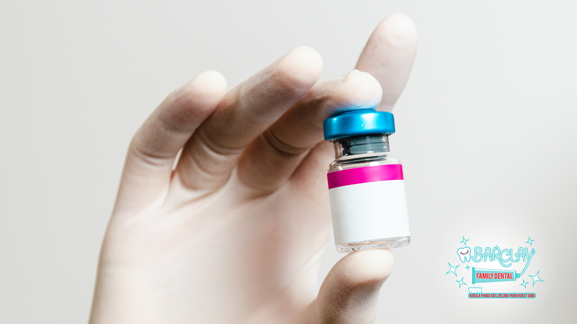 A person is holding a bottle of vaccine in their hand.
