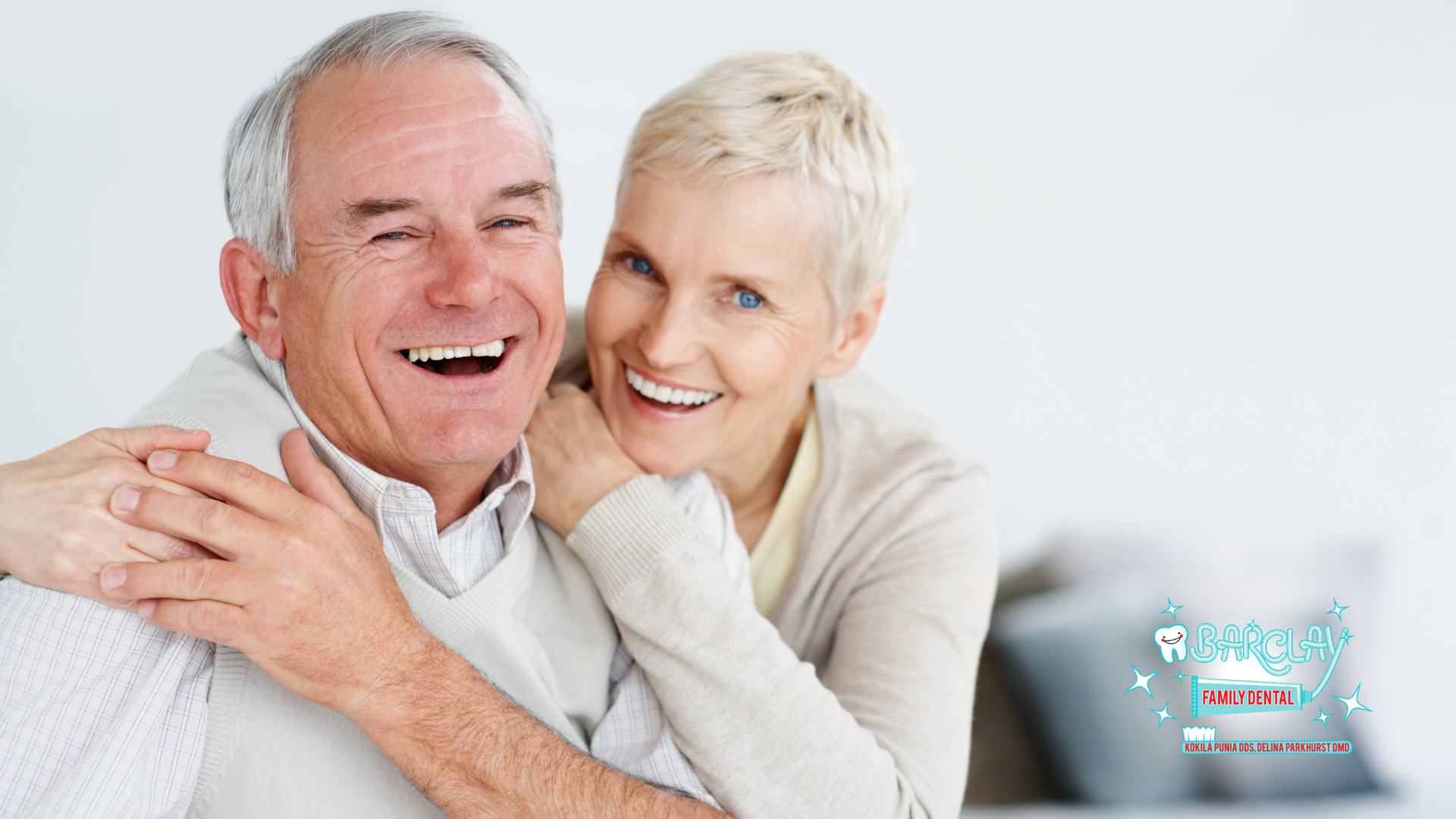 A man and a woman are hugging each other and smiling.