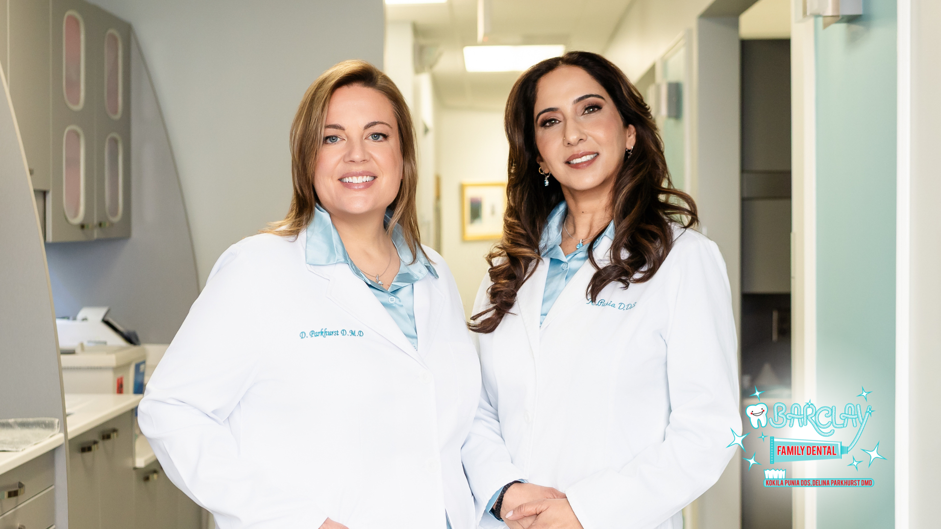 Two doctors in white coats standing in a bright medical office hallway