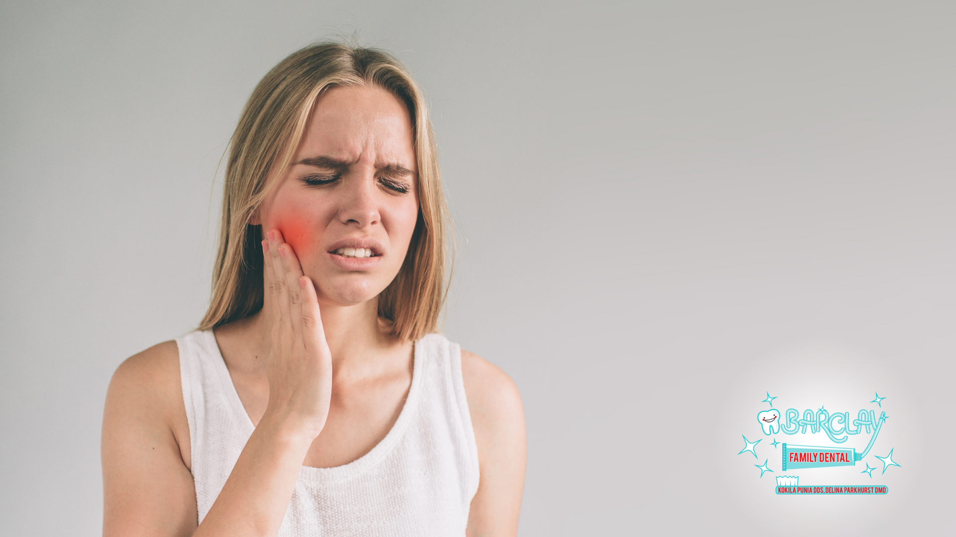 Woman with a painful expression, holding her jaw; red area indicates pain. Light background.