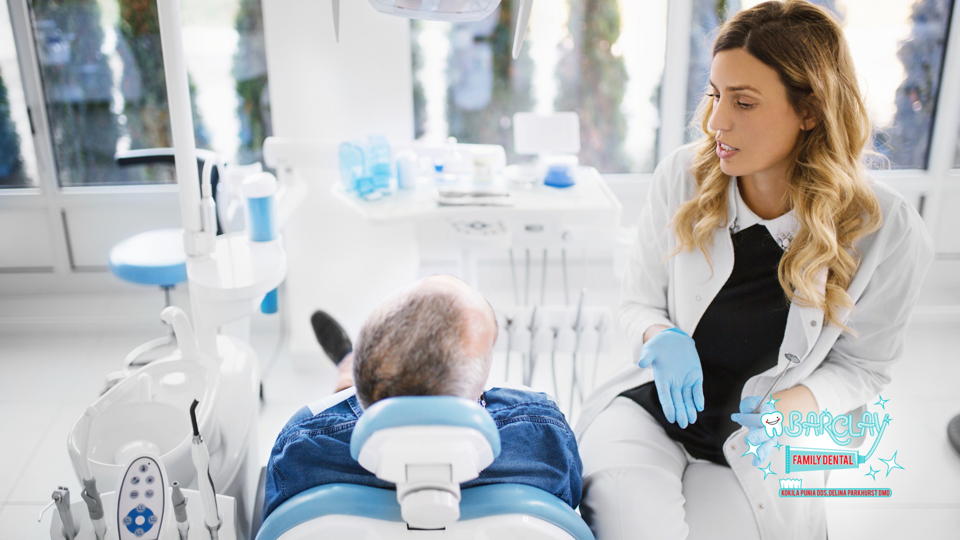 A dentist is talking to a patient in a dental chair.