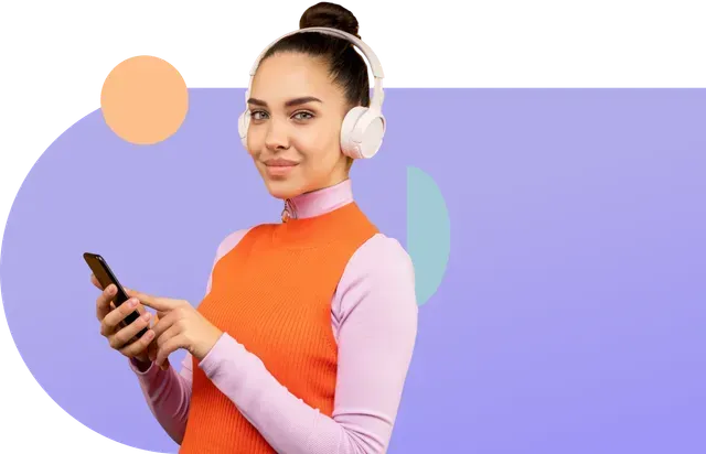 Une femme portant des écouteurs tient un téléphone portable.