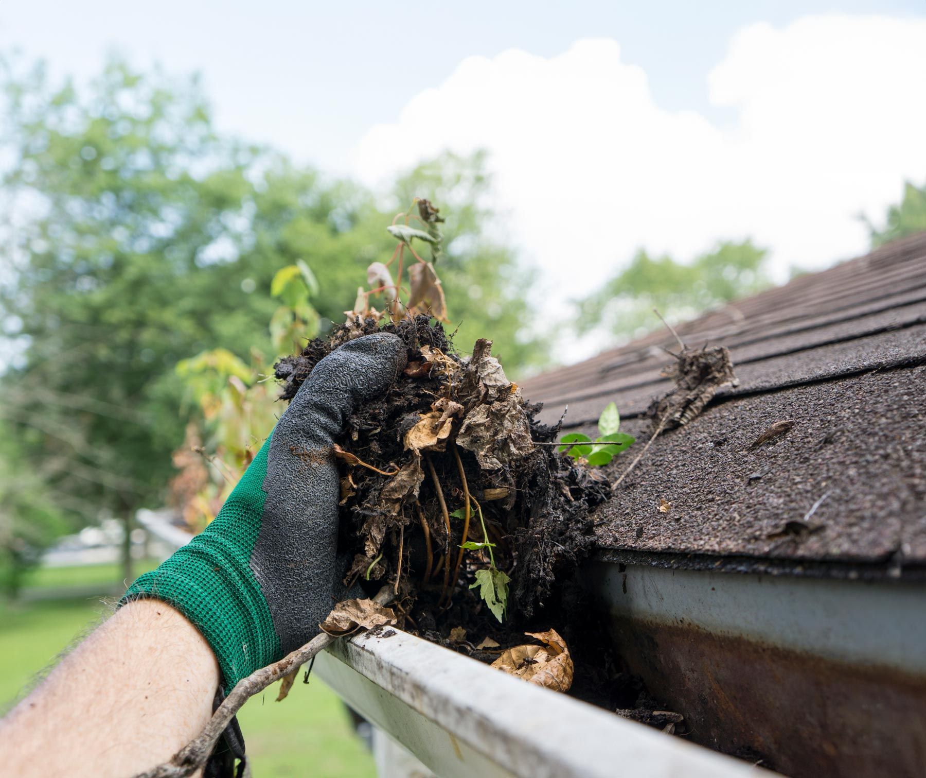 Worker Cleaning Gutter — Stevensville, MT — 406 Seamless Gutters