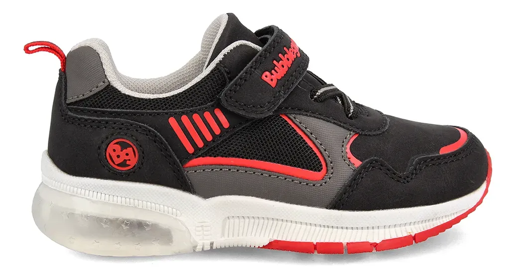 Zapatilla deportiva infantil negra y roja con suela luminosa y cierre de velcro.