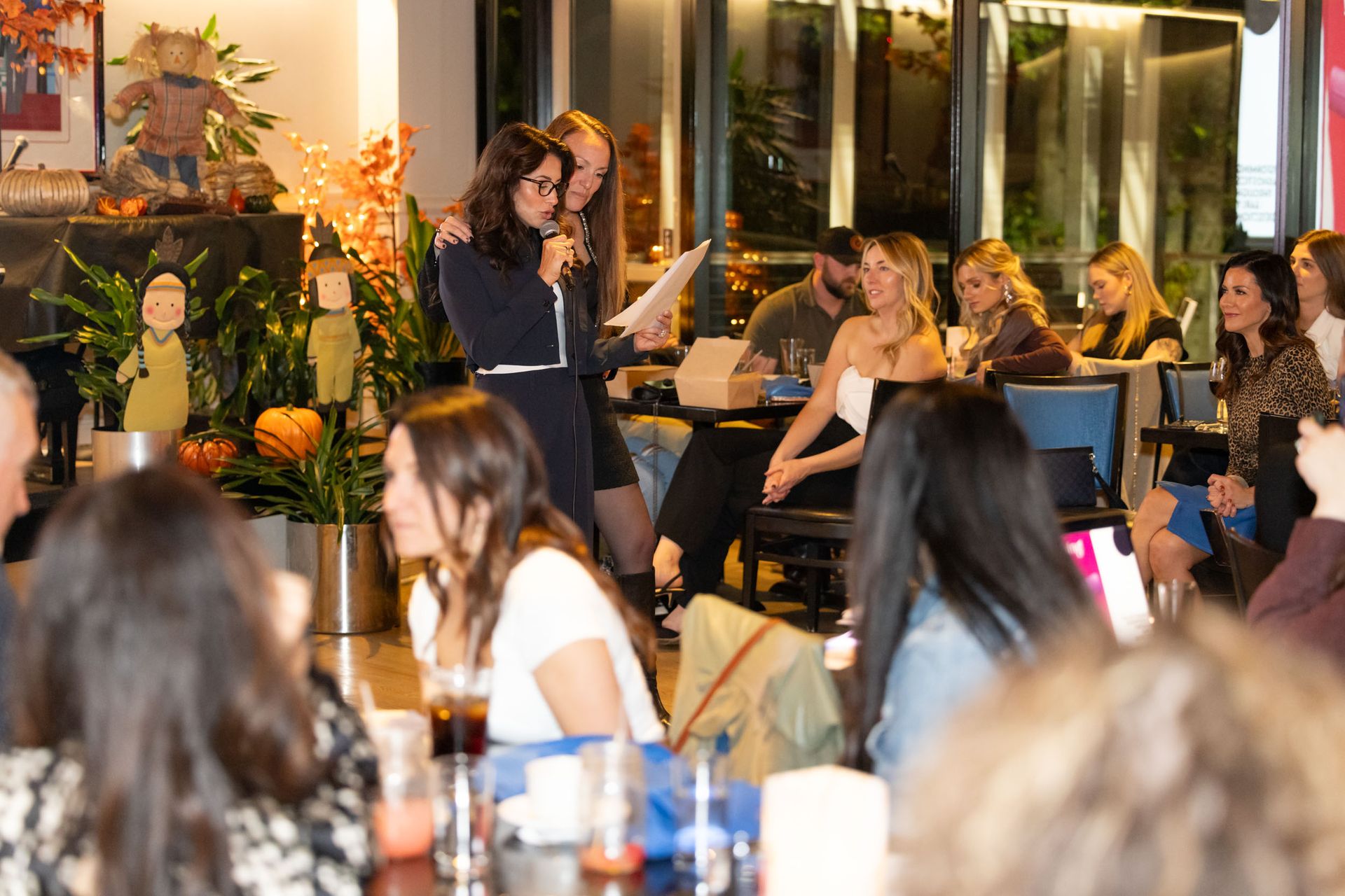 A group of people are sitting at tables in a restaurant.