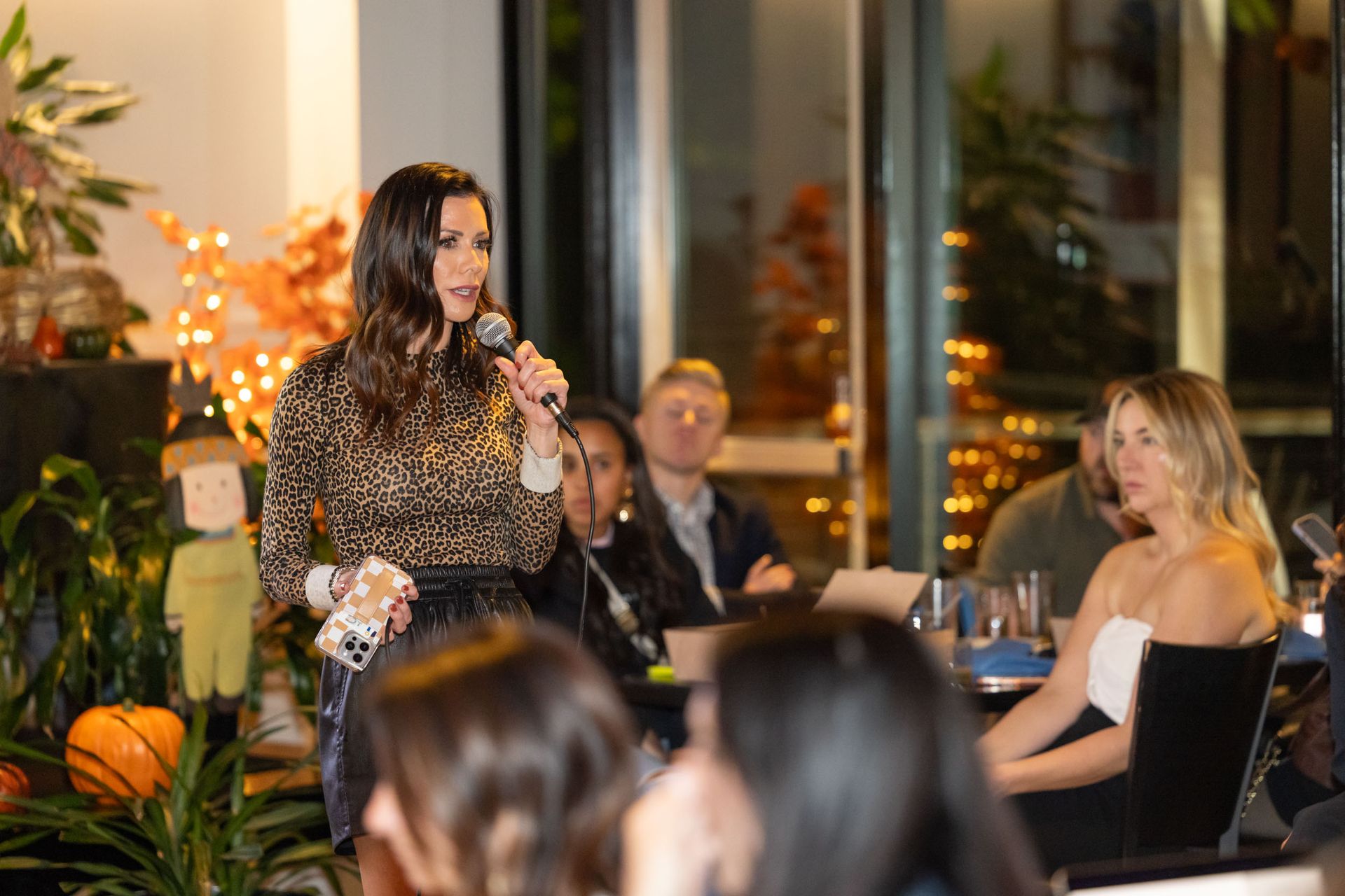A woman is holding a microphone in front of a group of people.