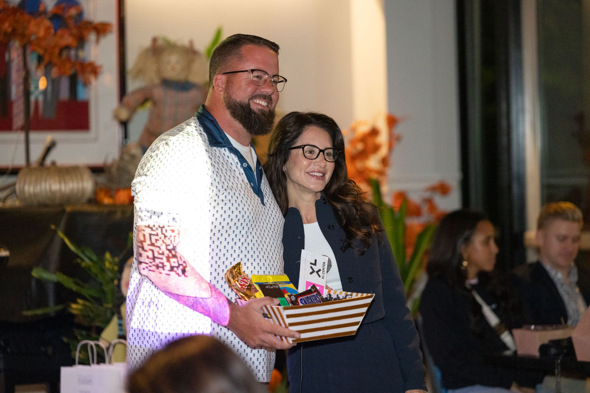 A man and a woman are standing next to each other holding a basket.