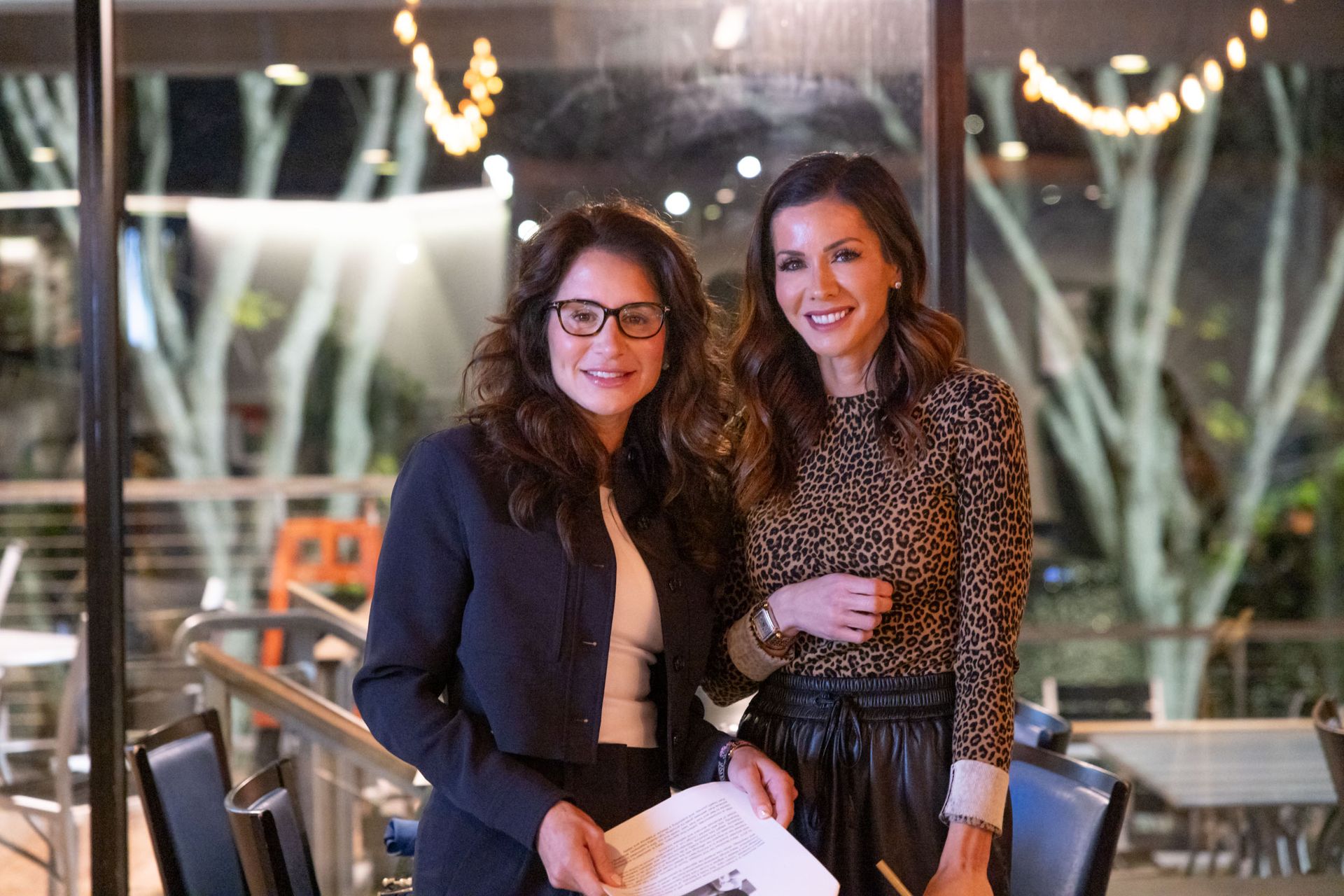 Two women are standing next to each other in a restaurant.