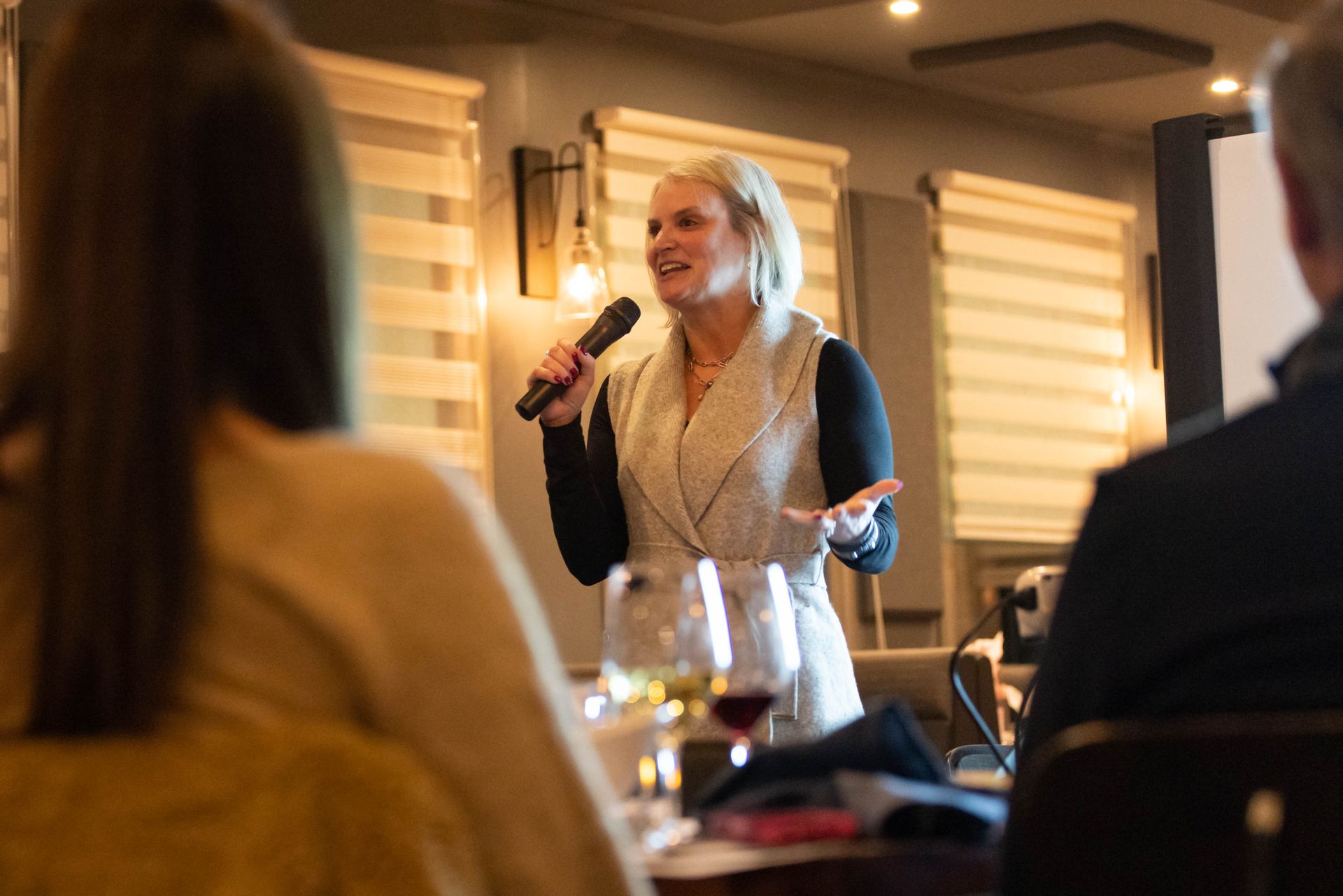 A woman is holding a microphone in front of a group of people.