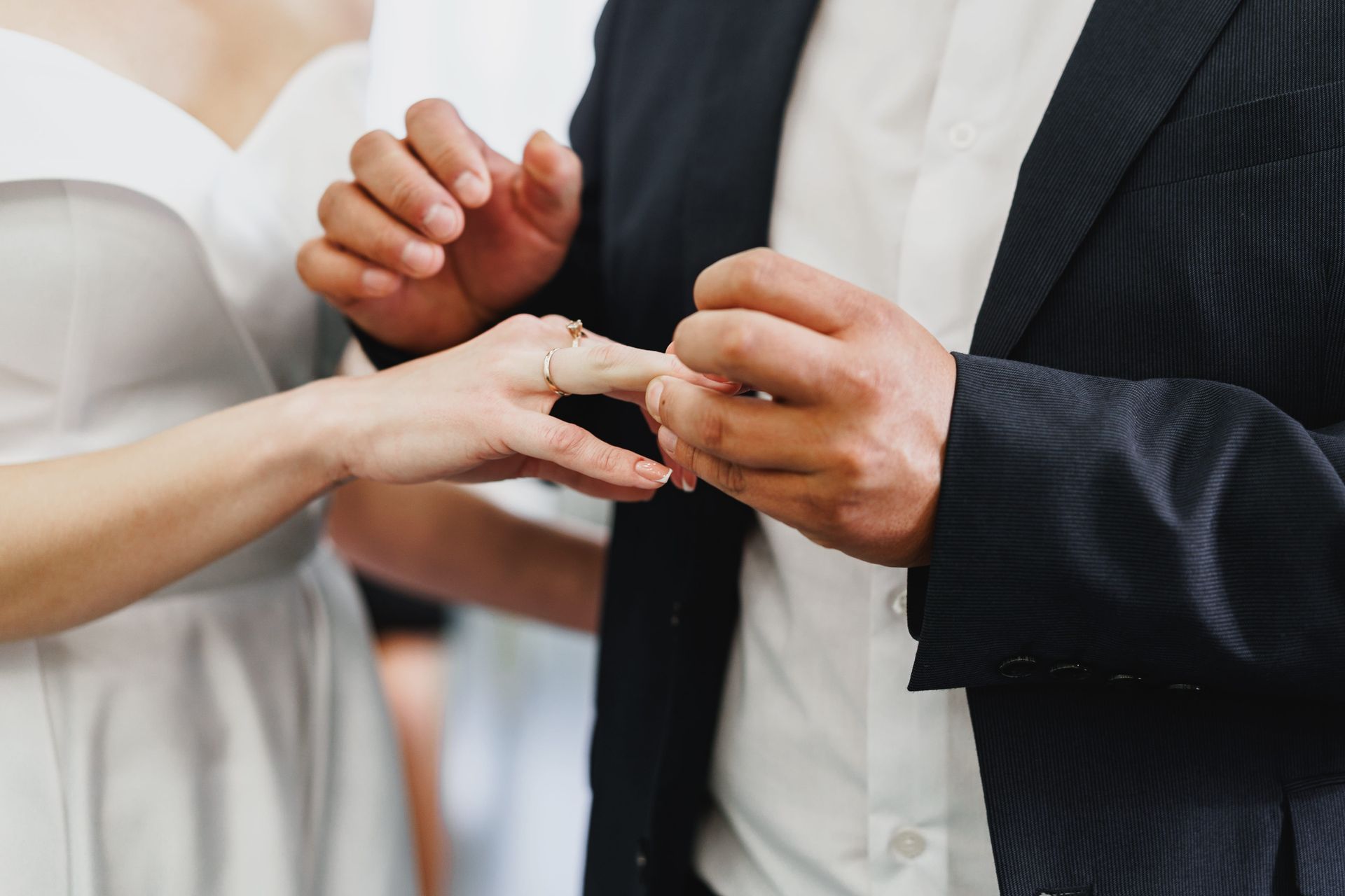 Hands placing a ring on a finger during a wedding ceremony