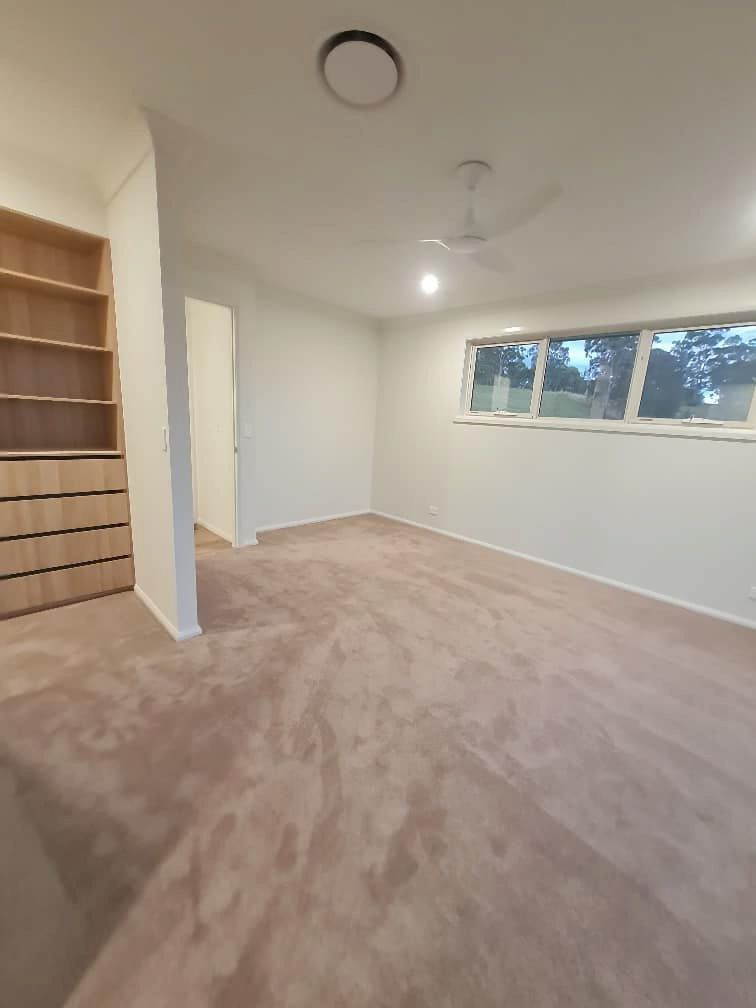 An Empty Room With A Ceiling Fan And A Window — Charmhaven Carpets In Charmhaven, NSW