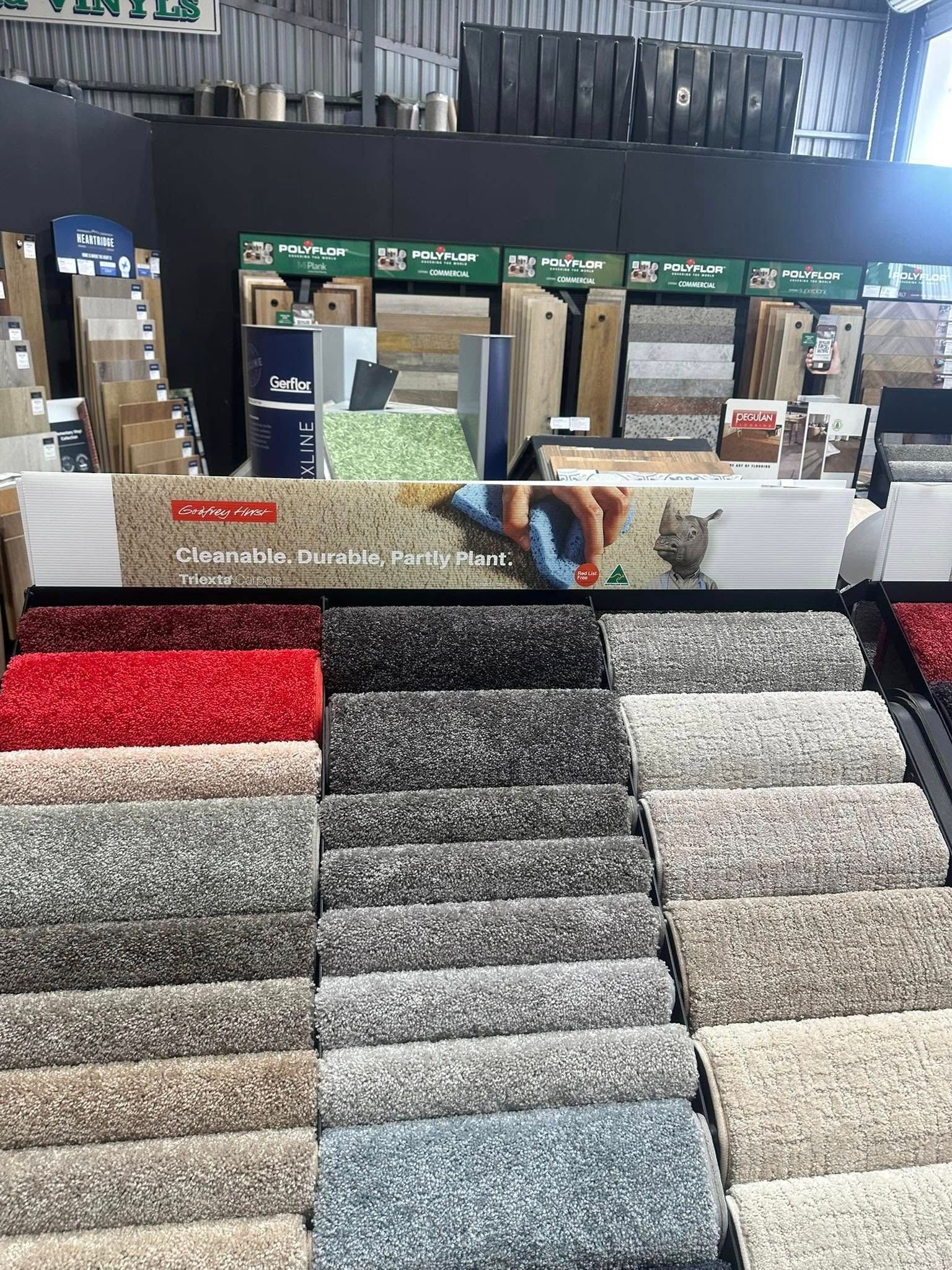 A Warehouse Filled With Lots of Colourful Rugs and Carpets — Charmhaven Carpets In Charmhaven, NSW