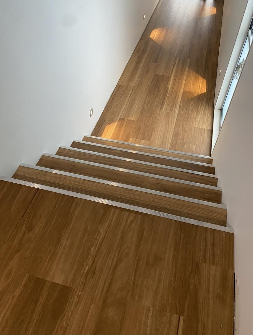 A Hallway With Wooden Stairs Leading Up to the Second Floor — Charmhaven Carpets in Newcastle, NSW