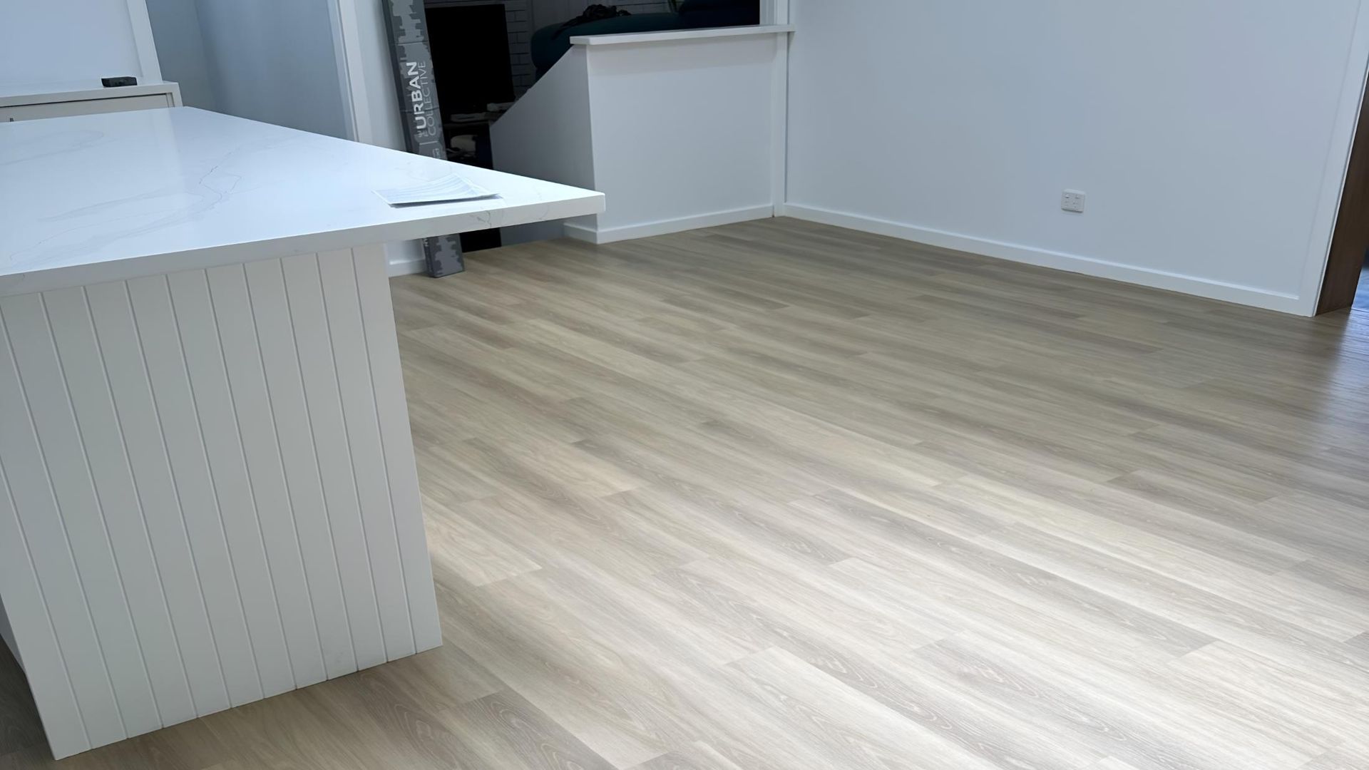 A living room with a wooden floor and a white table — Charmhaven Carpets in Newcastle, NSW