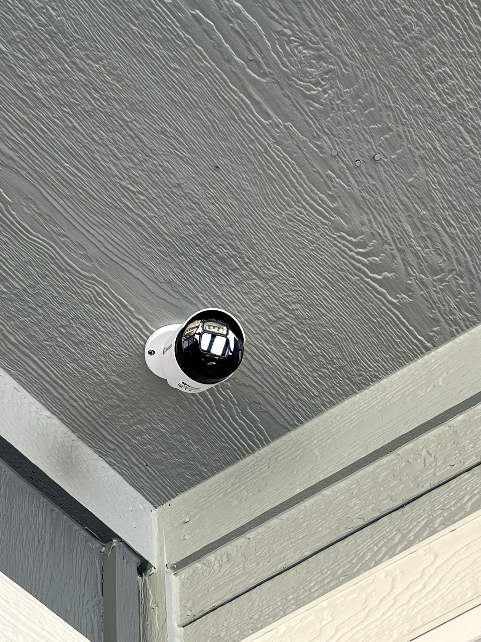 Close-up of a gray textured metal corner with a shiny black screw head.