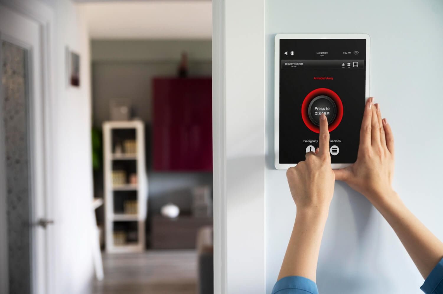 Hands using a wall-mounted smart home control panel in a doorway, selecting a circular touch control.