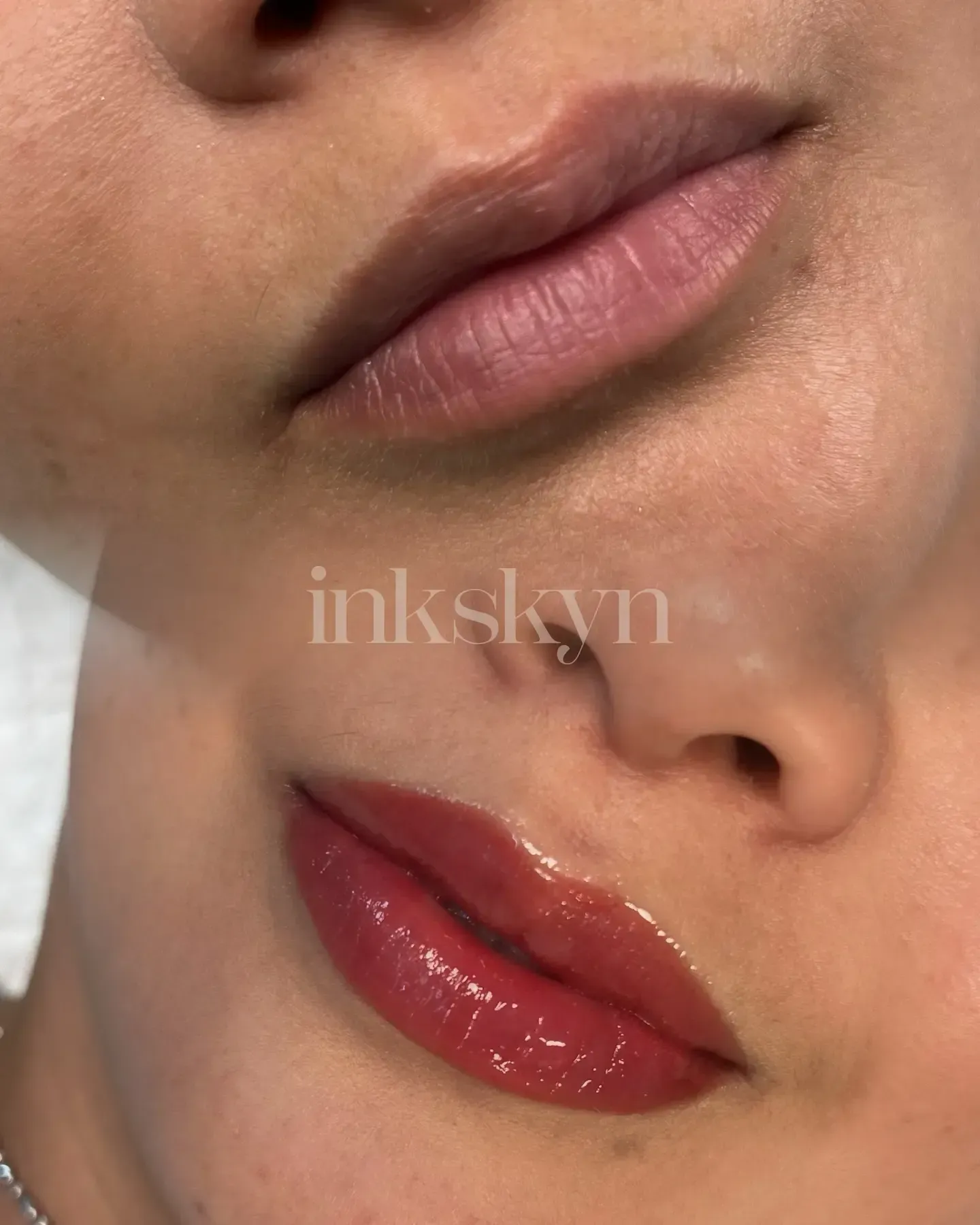 A close up of a woman 's lips with ink skyn written on the bottom