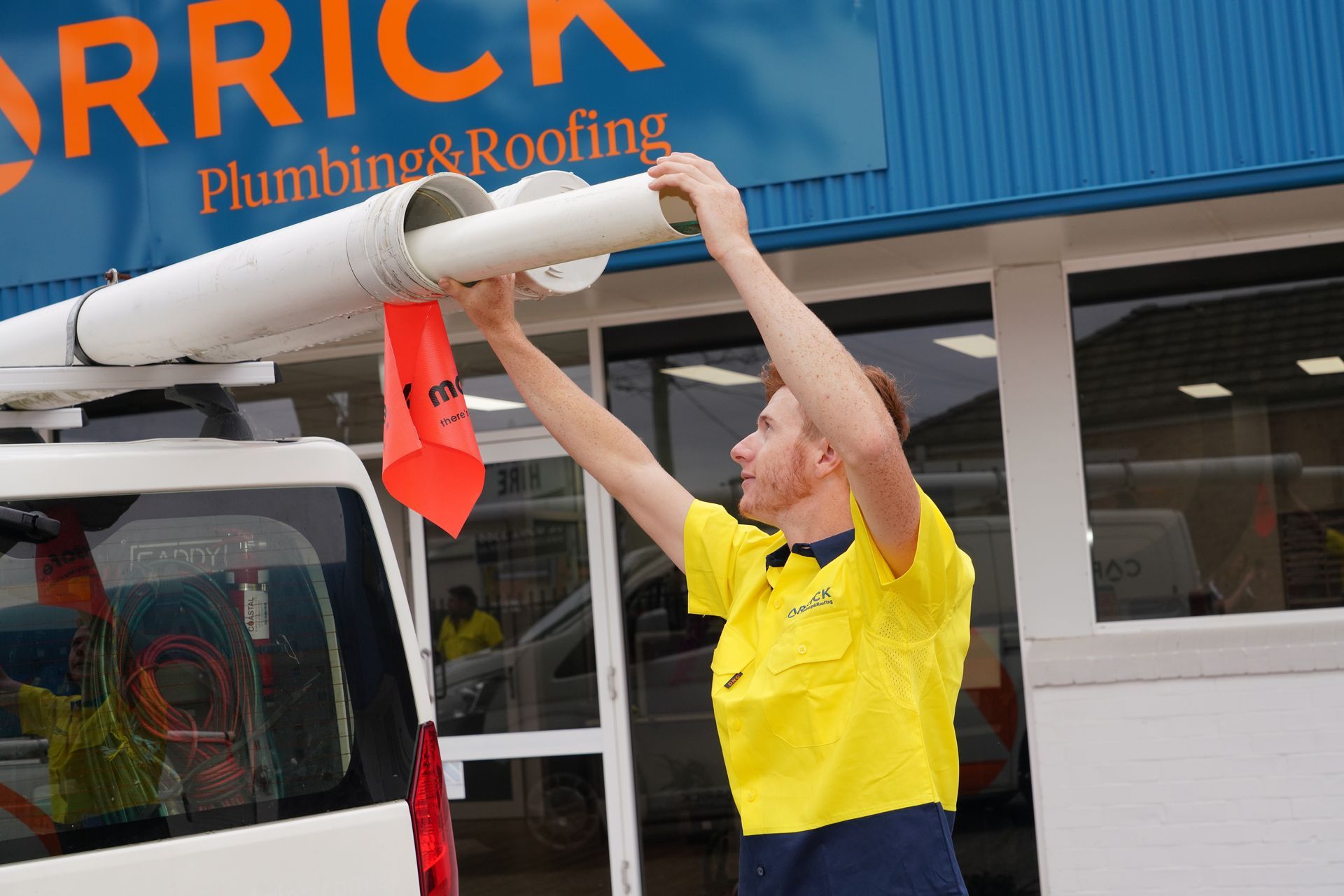 Carrick Pluming team member placing PVC piping onto there work vehicle. 