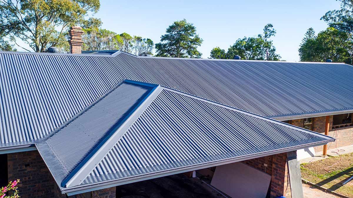 Roofing restoration image of the top of a Port Macquarie home displaying a metal re-roof completed by Carrick Plumbing & Roofing