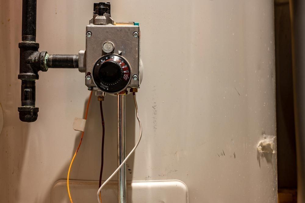 A close up of a hot water system heater with a thermostat attached to it.