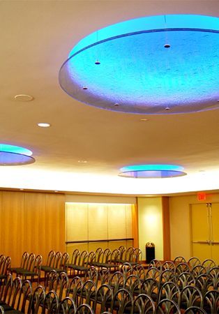 A room with rows of chairs and a blue light on the ceiling