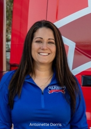 Smiling woman in a blue polo standing before a red and white backdrop