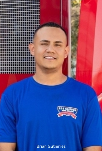 Man in a blue shirt standing in front of a red wall and metal mesh background