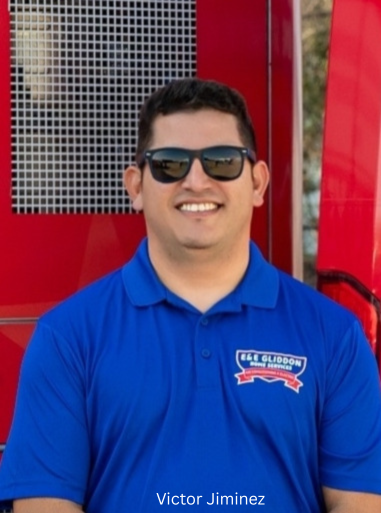 Smiling man in sunglasses wearing a blue polo shirt against a red background