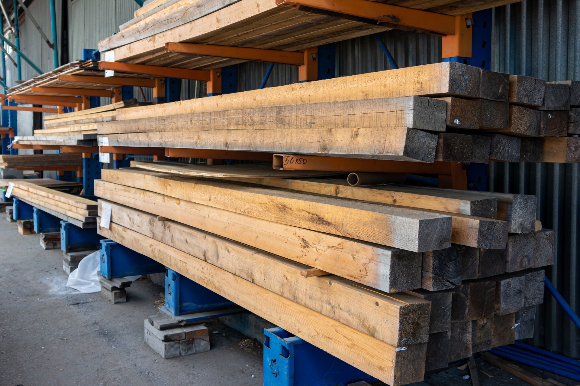 Wooden beams stacked on industrial storage racks.