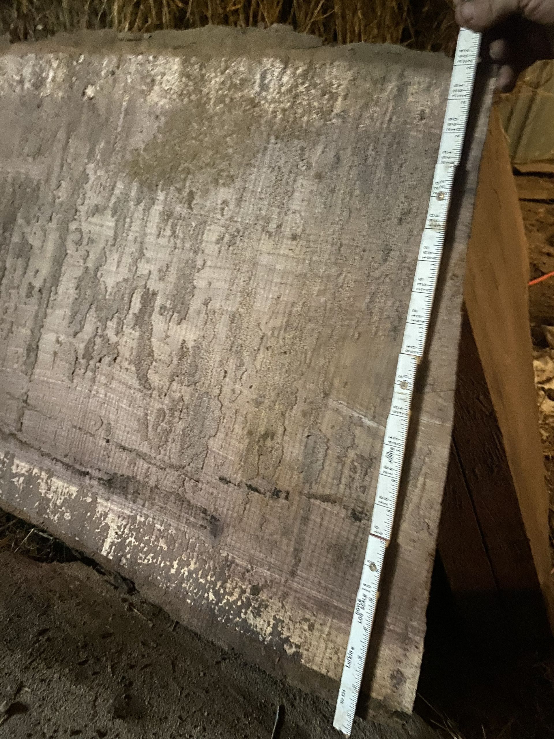 A wooden plank with a measuring tape next to it, showing the height.