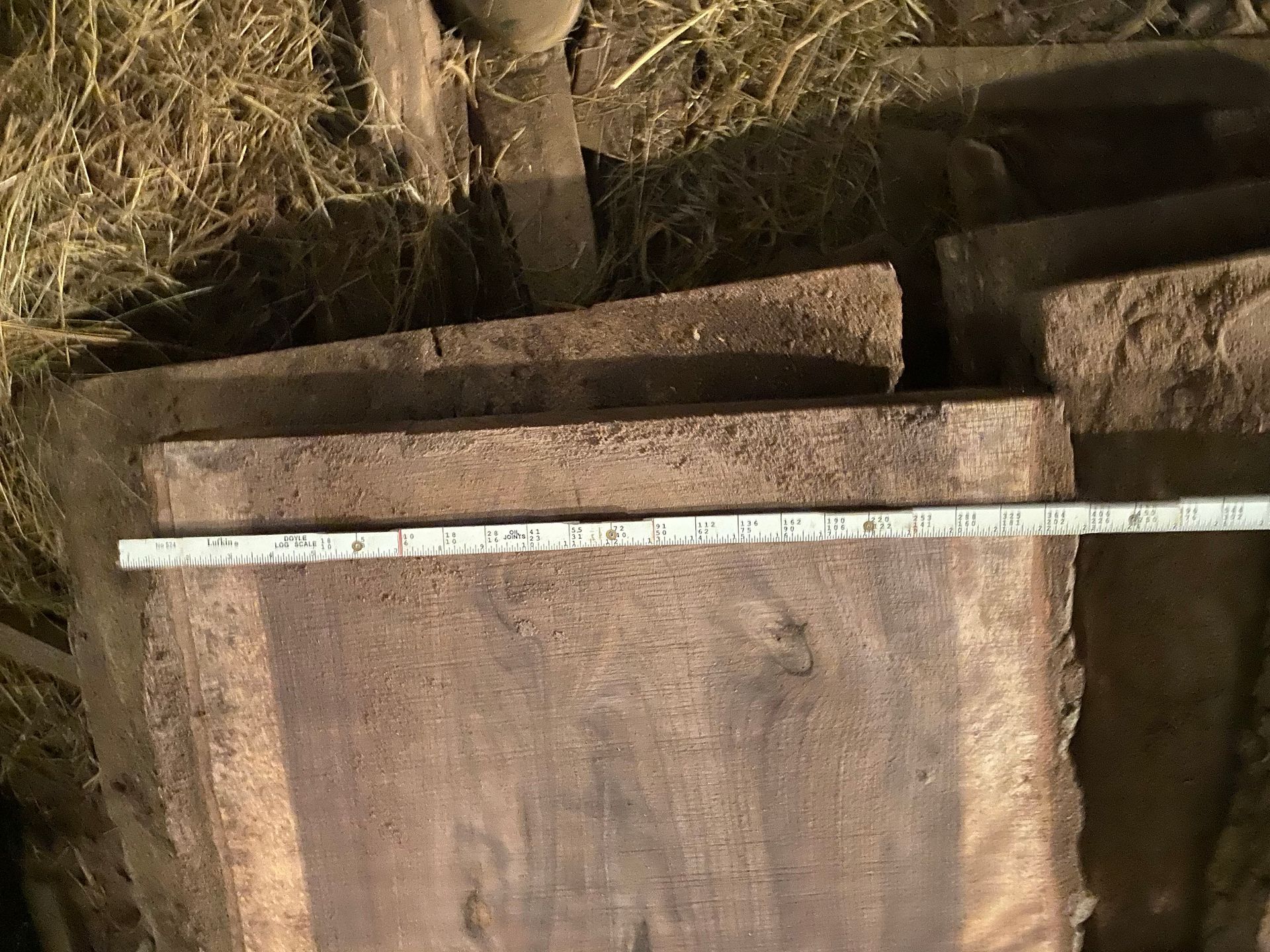 Wooden planks stacked with a measuring tape across the bottom one.