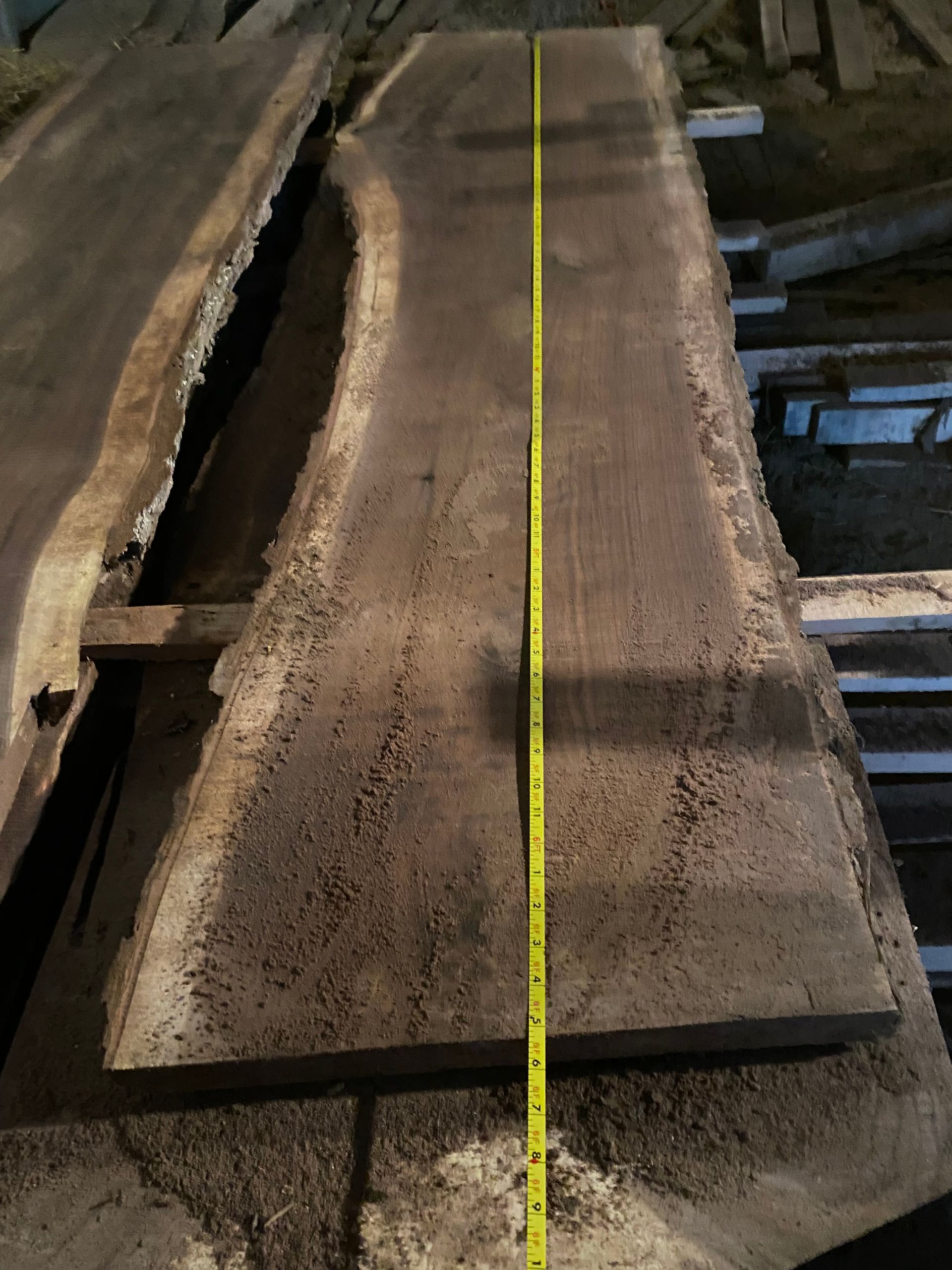 Dark wood slab with a yellow tape measure running along its length.