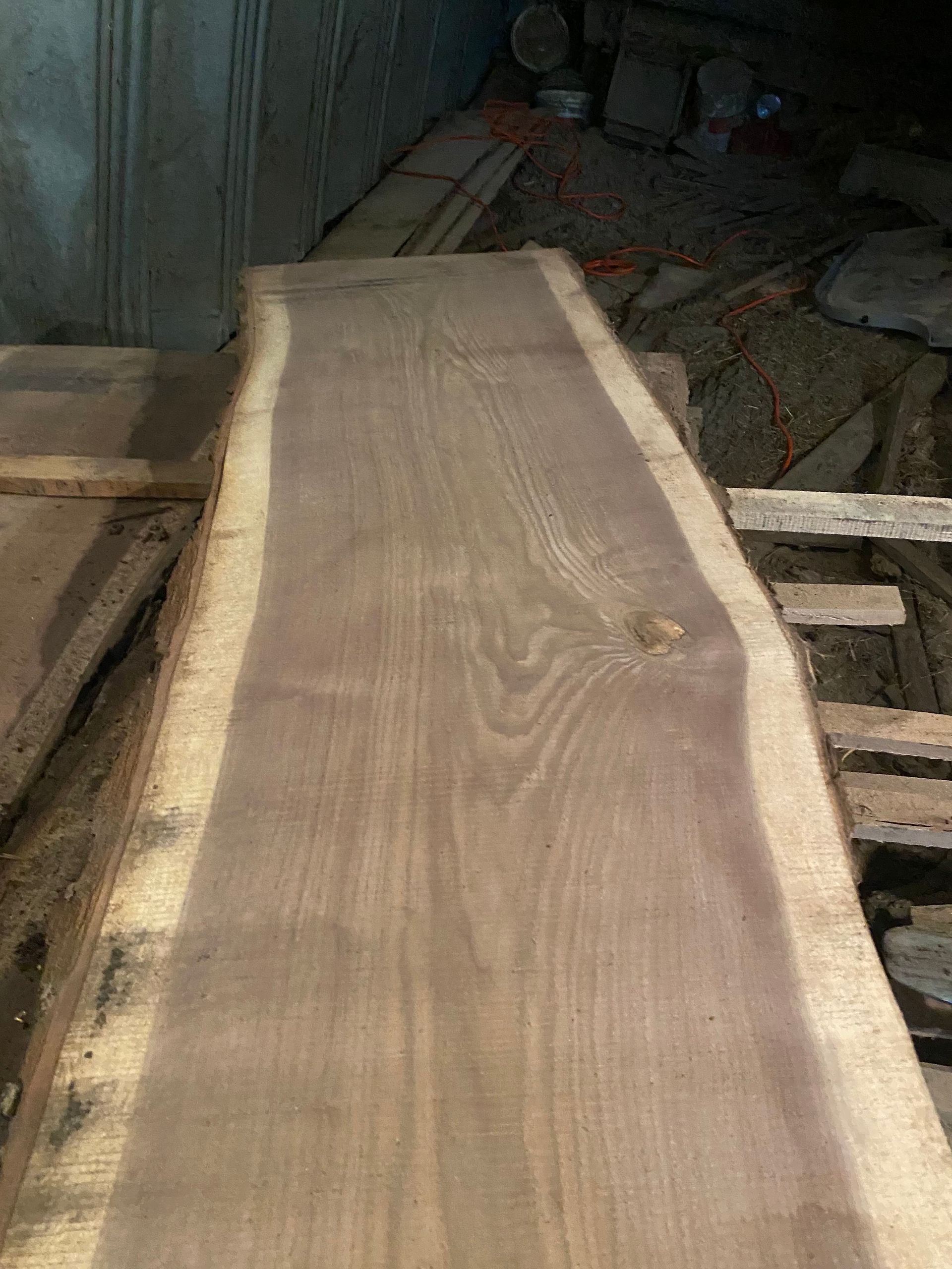 Long, unfinished wooden plank with natural edge, light brown color.