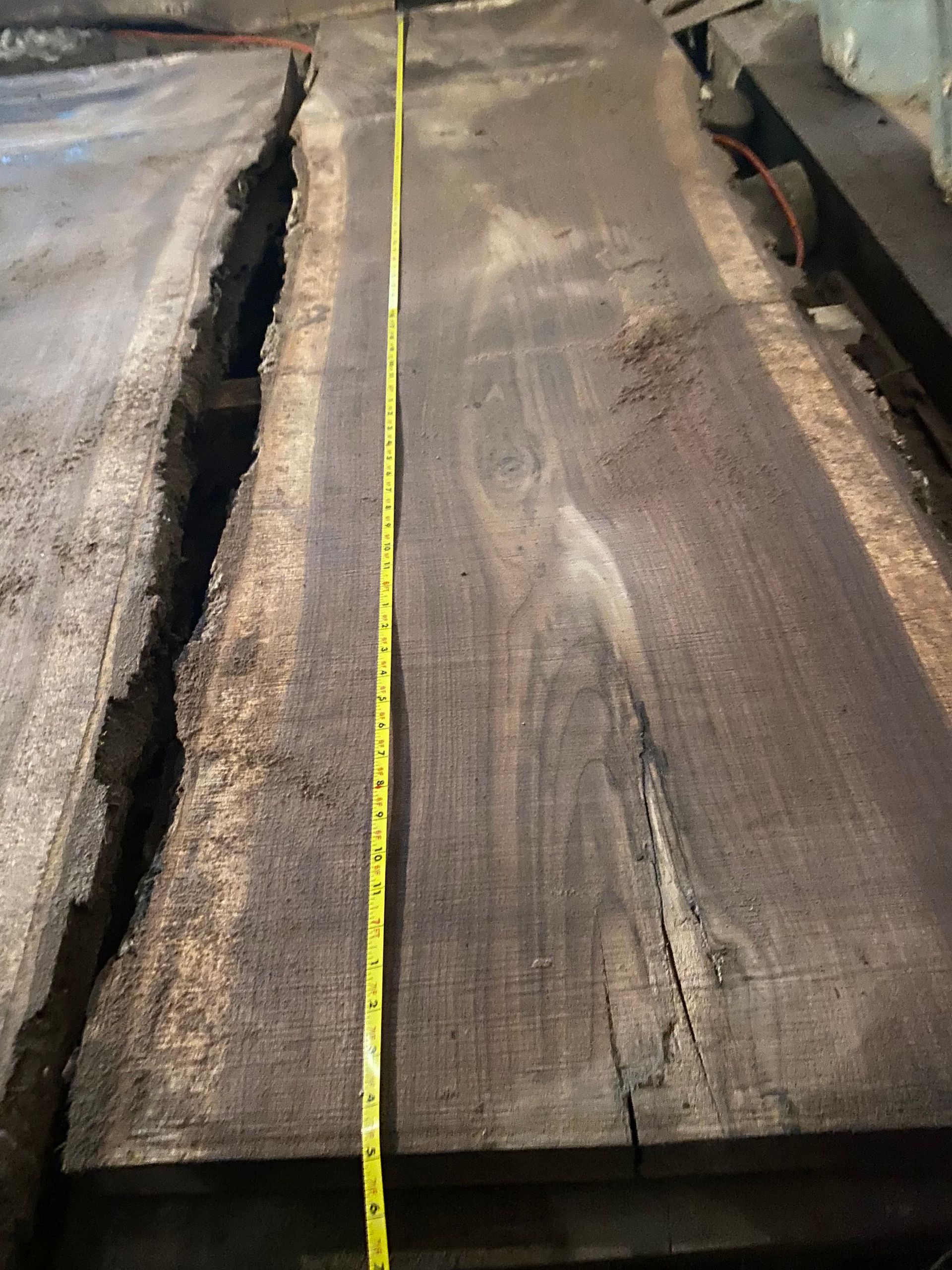 Wooden planks with a yellow tape measure laid across them.
