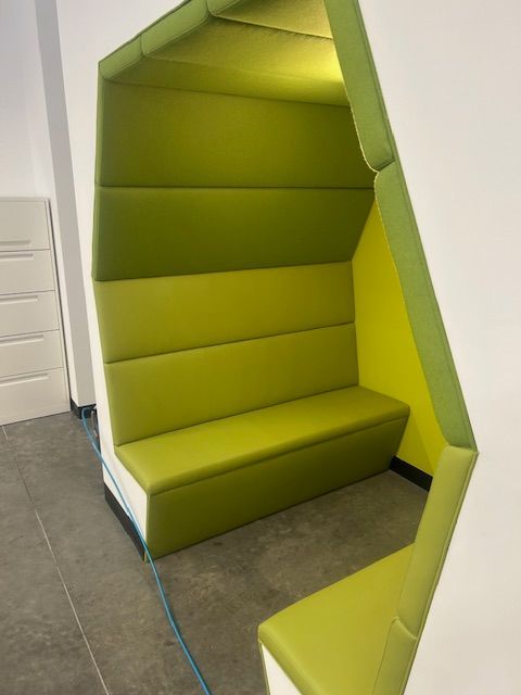 A green and yellow couch in a corner of a room