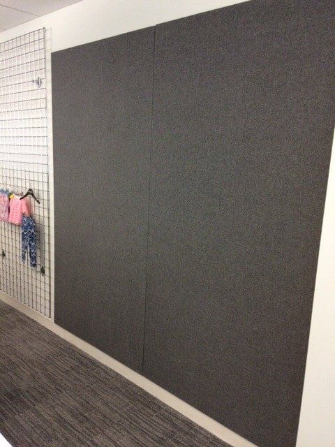 A gray wall with clothes hanging on it