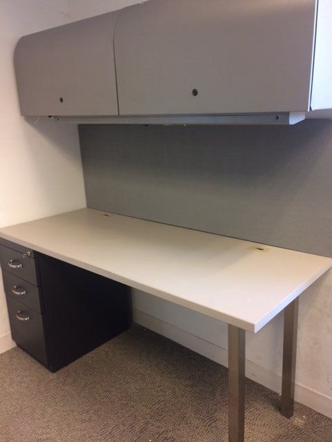 A white desk with a black filing cabinet underneath it