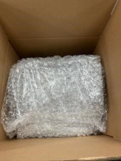 A cardboard box filled with bubble wrap and plastic wrap.
