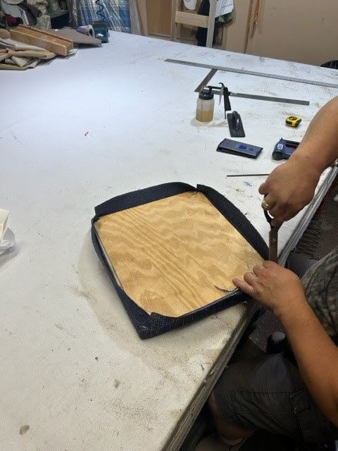A person is cutting a piece of wood with scissors