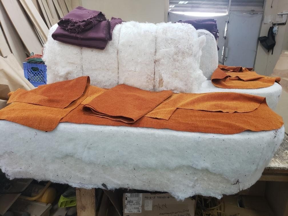 A couch with a lot of pieces of fabric on it