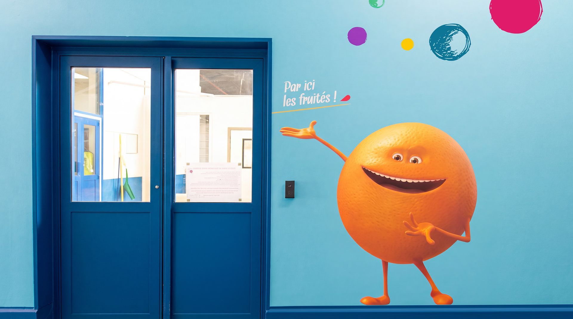 Habillage des couloirs de l'usine avec l'orange géante d'Oasis.