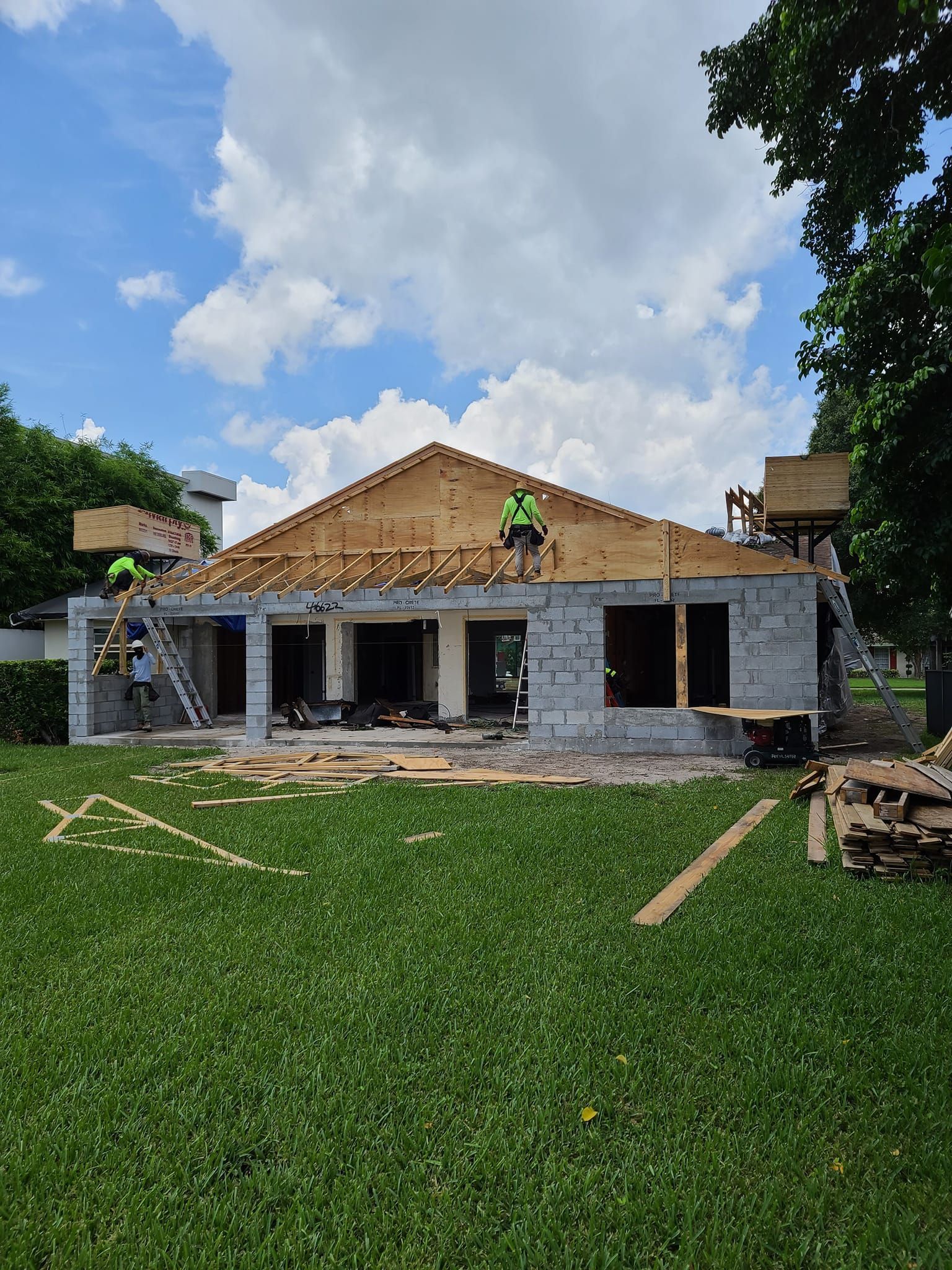 A house is being built with workers on the roof.