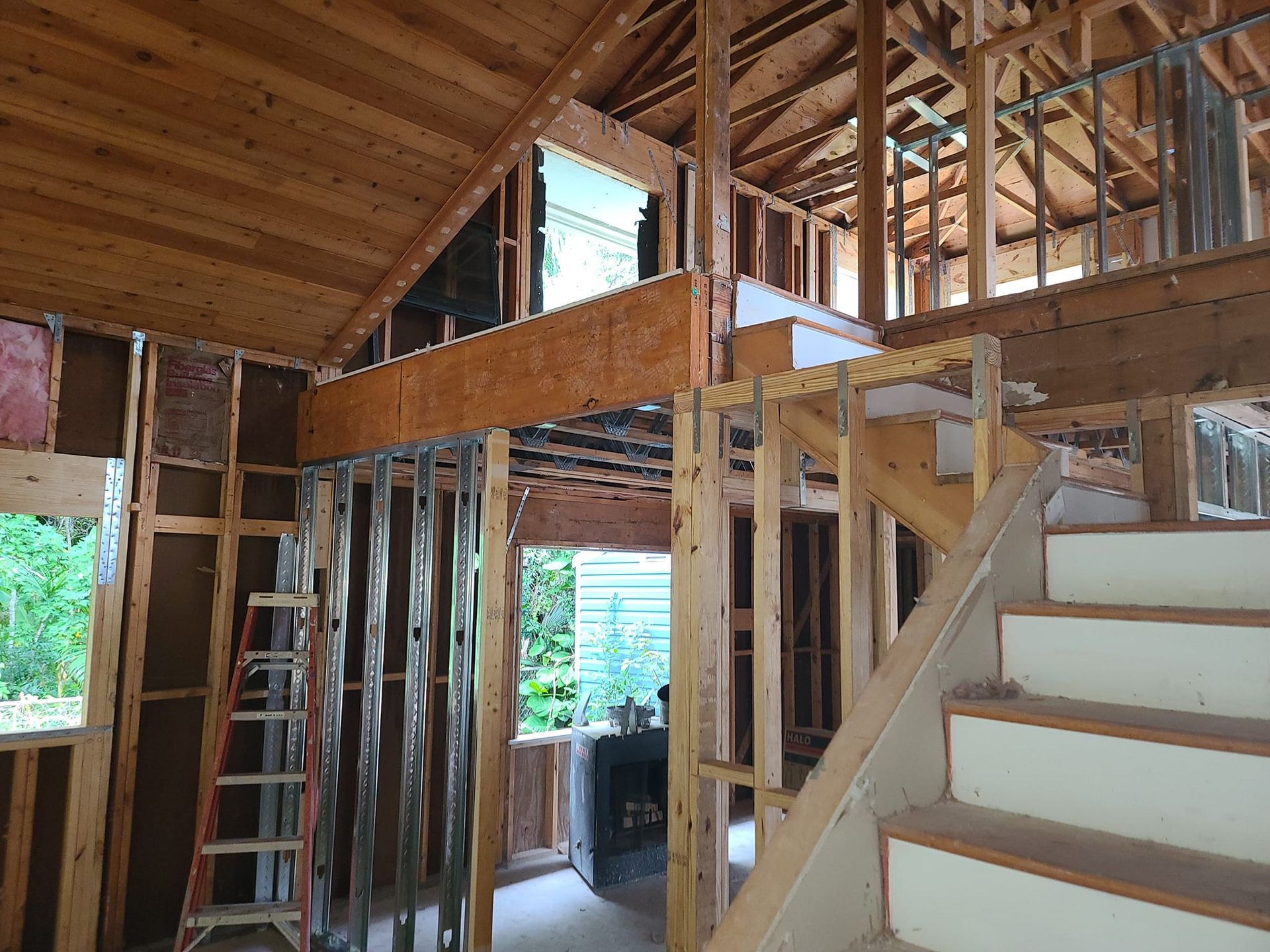 A house is being built with wooden beams and stairs.