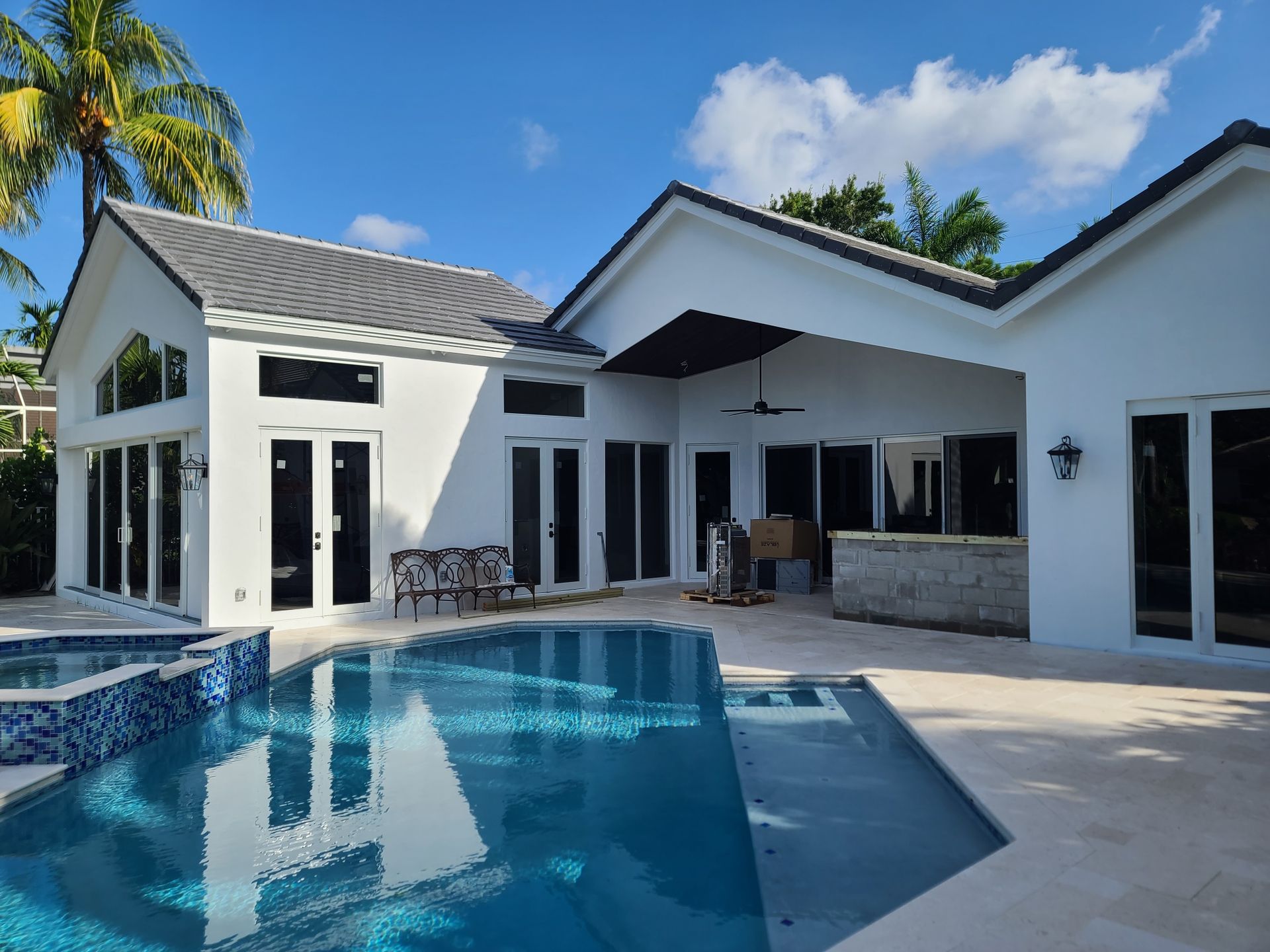 A modern white house with a pool in a sunny setting.