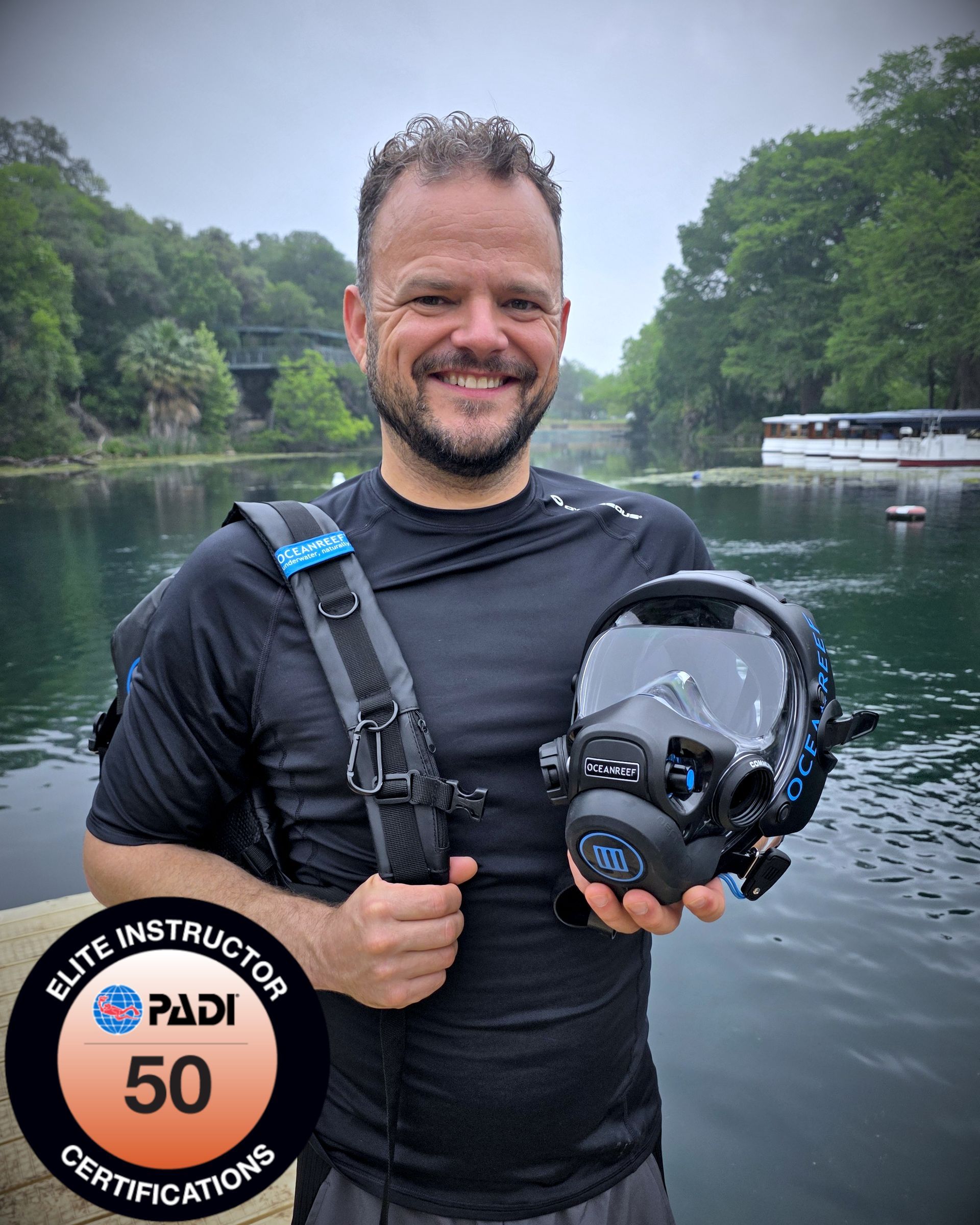 Man in diving suit smiles, gives 