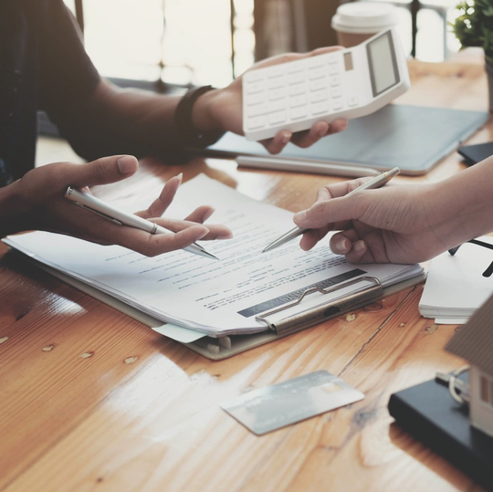 Two people are sitting at a table looking at papers