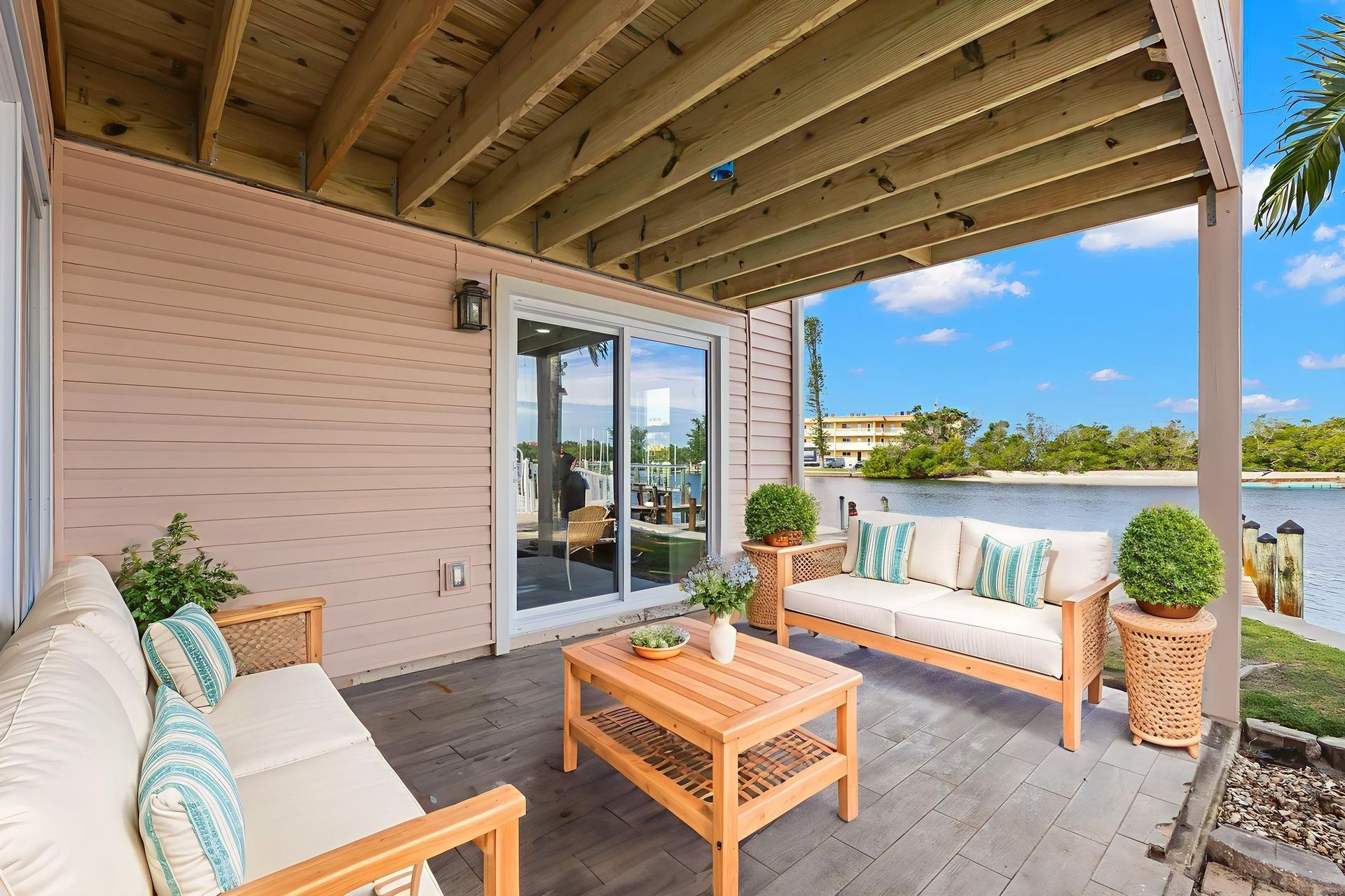 A grill is sitting on a deck overlooking a body of water.