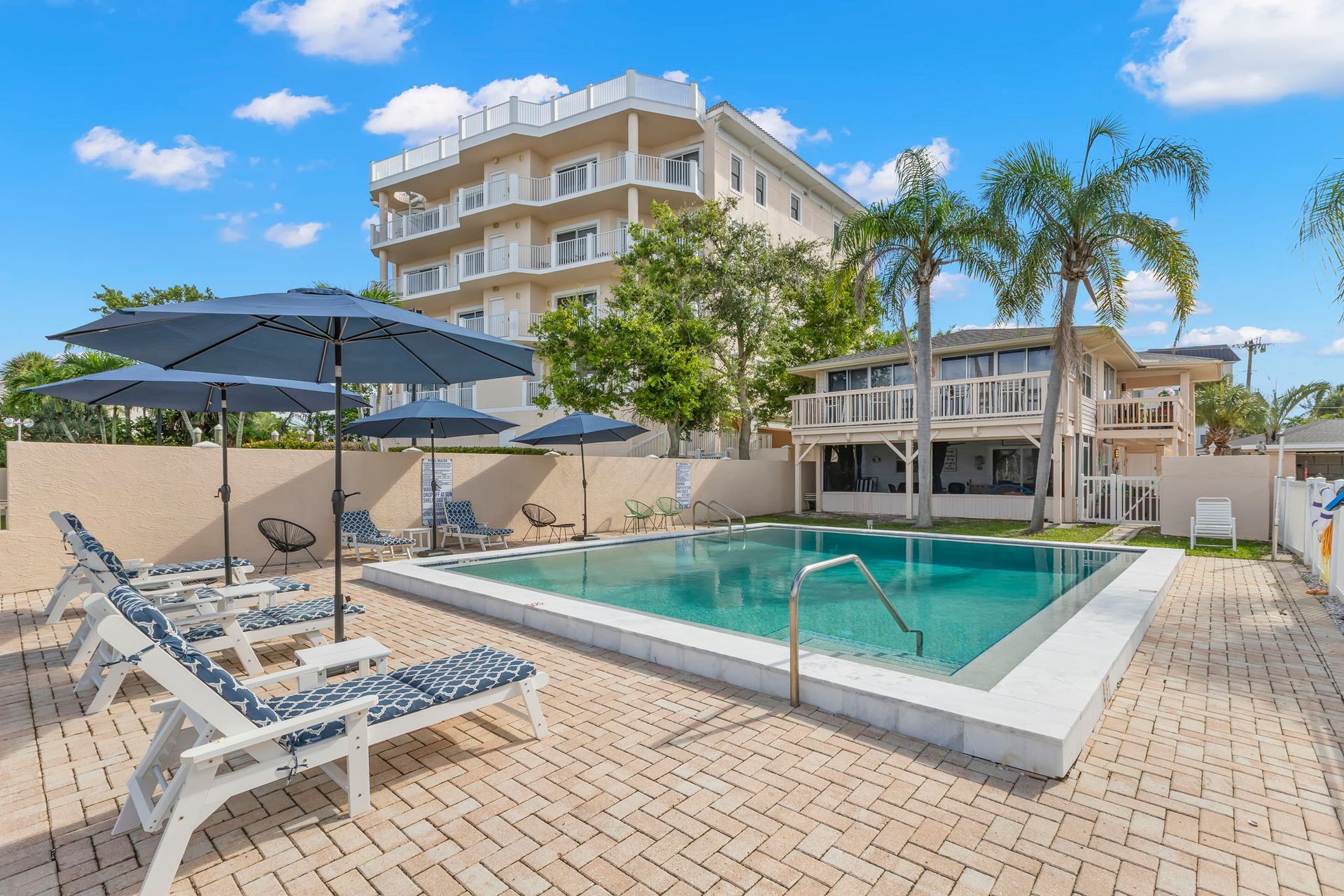 A large swimming pool surrounded by chairs and a fence