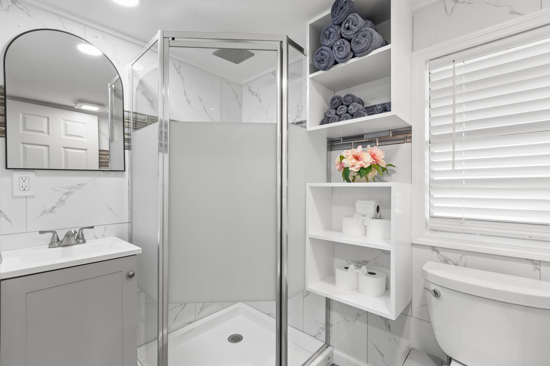 A bathroom with a toilet , sink , and shower.