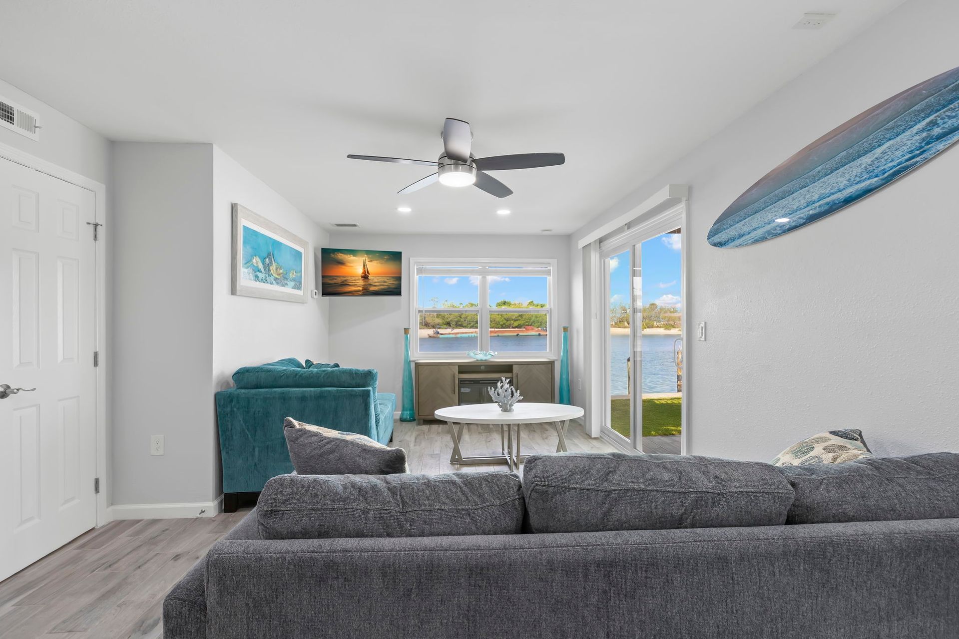 A living room with a couch , coffee table , and ceiling fan.